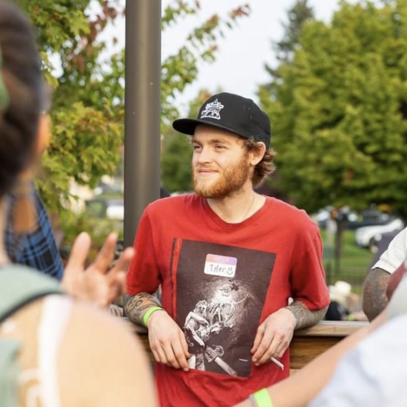 Man with name tag Tyler smiling and networking at a cannabis community gathering
