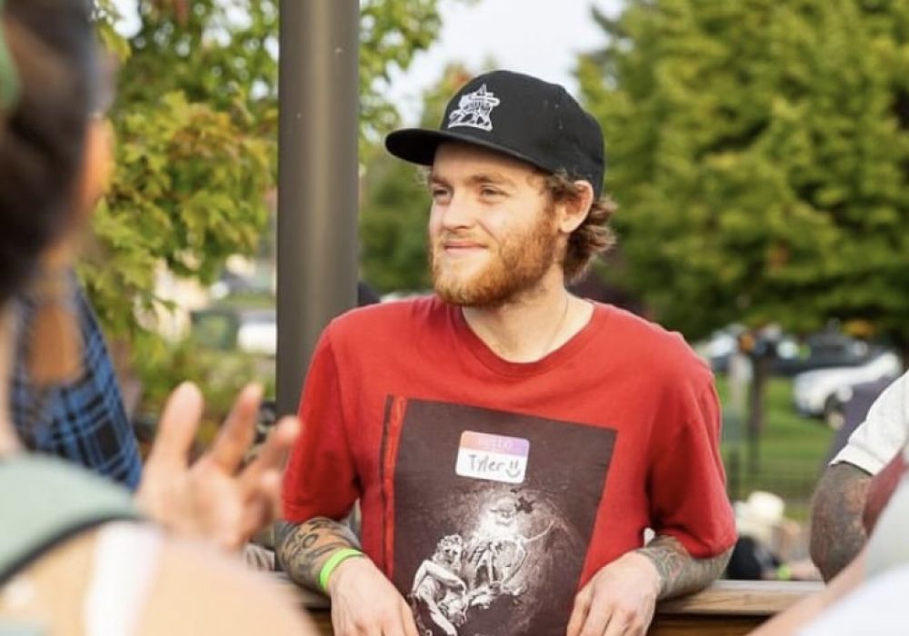 Man with name tag Tyler smiling and networking at a cannabis community gathering